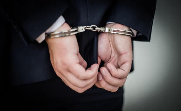 man in suit handcuffed
