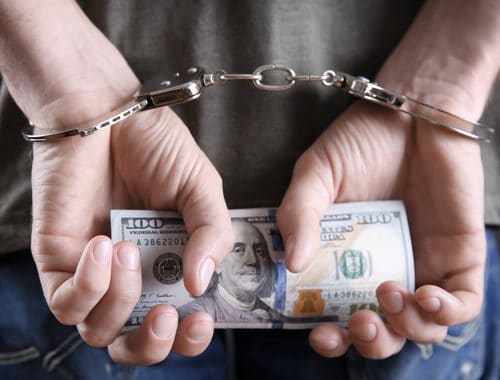 handcuffed holding money